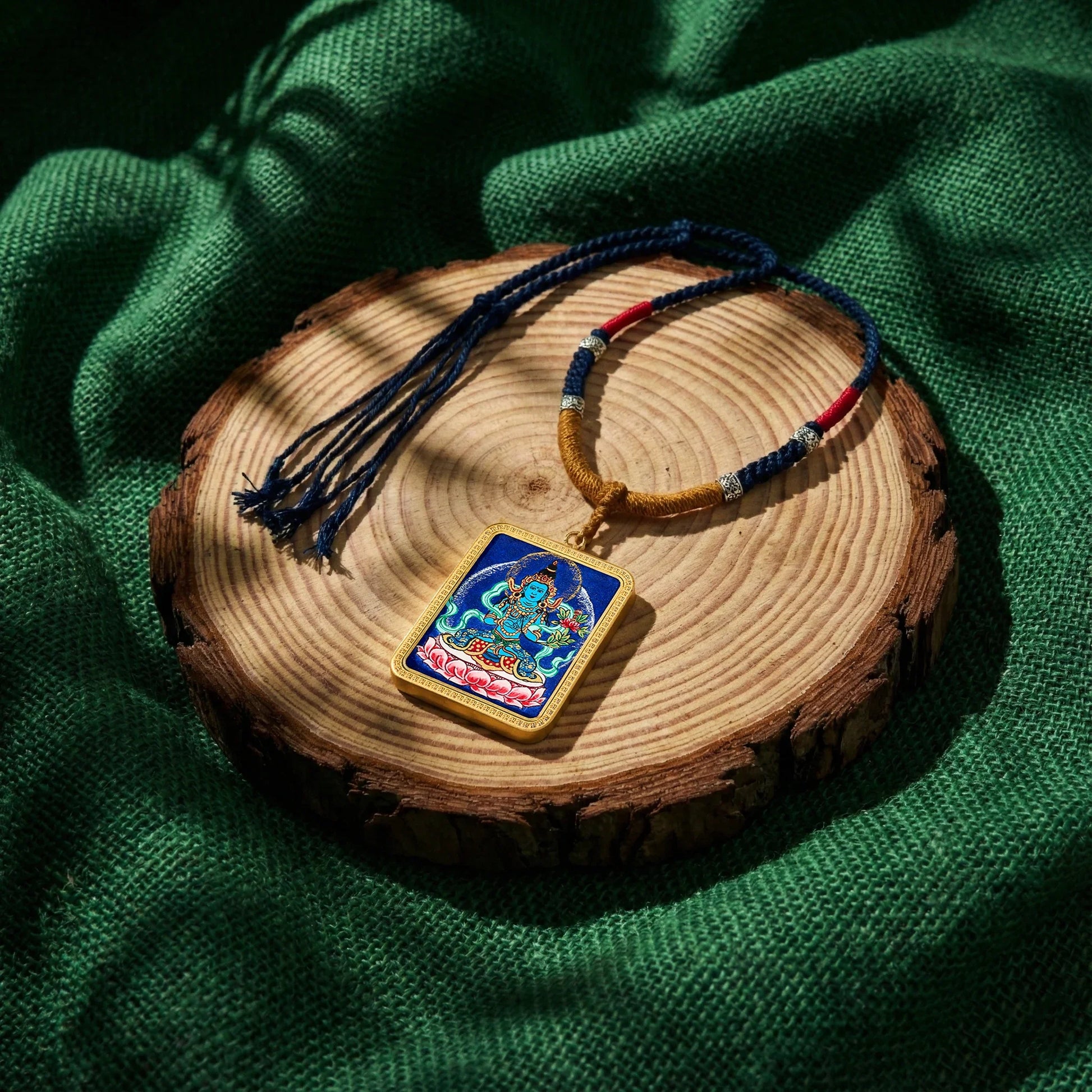 Tibetan Buddhist thangka pendant necklace on wooden slab with woven cord, spiritual jewelry